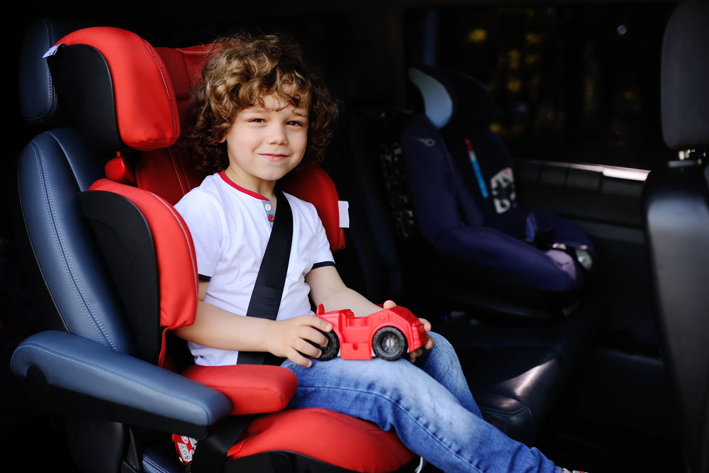 Jeune enfant installé dans un siège auto dans la voiture